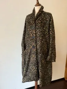 A loose-fit leopard-print coat in earthy tones displayed on a dress form.