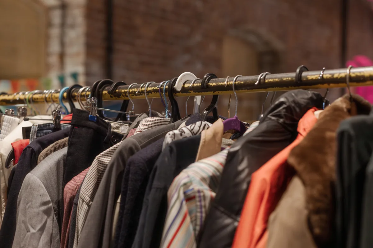 A long clothing rack packed with diverse jackets and coats in various colors and styles.