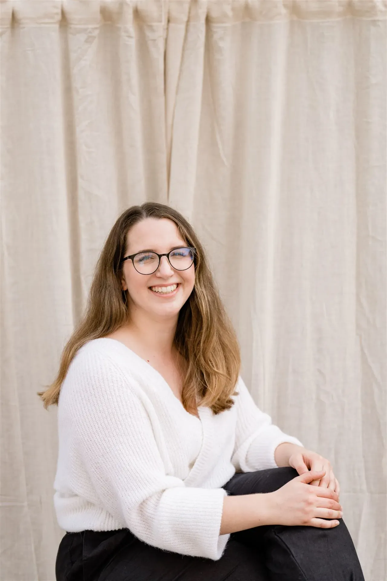 Portrait of Rahel Hohl seated confidently, radiating the approachable, authentic spirit behind the Face and Sugar studio.