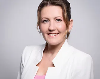Viktoria, the mobile foot care specialist, smiles warmly in professional attire — building trust and a personal connection with readers.