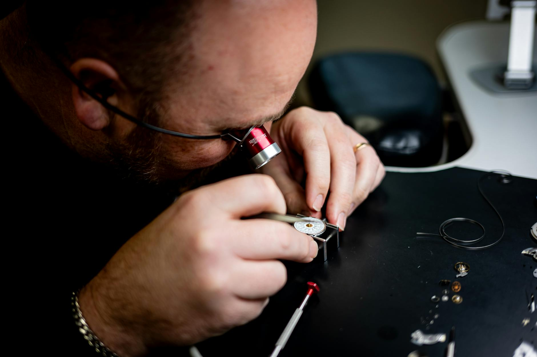 watchmaker inspecting movement