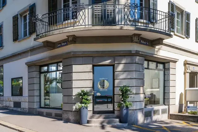 The elegant corner storefront of Ana Novotny Hair salon situated in a classic Zurich Seefeld building.