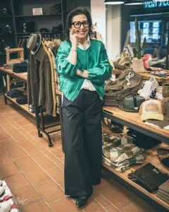 A stylish woman in a green jacket poses confidently inside the RAW Station store.