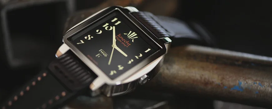 Close-up of the Knecht watch showcasing its distinctive square case, black dial, and gold hands.